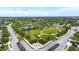 An aerial view of a neighborhood park featuring green space, playground, and sidewalks at 4691 Claremont Park Dr, Bradenton, FL 34211