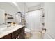 Neat bathroom including a single vanity and shower with white shower curtain at 4691 Claremont Park Dr, Bradenton, FL 34211