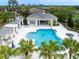 Aerial view of a community pool with cabana, lounge chairs, and clear, blue water at 4691 Claremont Park Dr, Bradenton, FL 34211