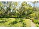 Expansive backyard with mature trees and lush lawn provides a spacious and private outdoor retreat at 4740 Carrington Cir, Sarasota, FL 34243