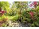Lush backyard featuring mature trees and flowering plants create a private and serene outdoor space at 4740 Carrington Cir, Sarasota, FL 34243