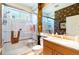 Bathroom featuring a glass-enclosed shower, toilet and sink with a marble countertop and vanity at 4740 Carrington Cir, Sarasota, FL 34243