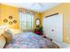 Bright bedroom featuring a queen bed, yellow walls, closet, and decorative wall art at 4740 Carrington Cir, Sarasota, FL 34243