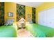 Cheerful bedroom with twin beds, bright yellow walls and colorful tropical themed decorations at 4740 Carrington Cir, Sarasota, FL 34243
