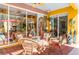 Outdoor lanai with wicker furniture, tile floors, and access to the enclosed pool area and dining area at 4740 Carrington Cir, Sarasota, FL 34243