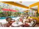 Inviting covered lanai with wicker furniture, a mosaic table, and view of the pool and tropical foliage at 4740 Carrington Cir, Sarasota, FL 34243