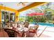 Enclosed lanai featuring comfortable seating, terracotta tile floors, and view of the pool and lush landscaping at 4740 Carrington Cir, Sarasota, FL 34243