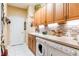 Laundry room with white washer/dryer and storage; decorated with brick wallpaper at 4740 Carrington Cir, Sarasota, FL 34243