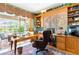 Spacious home office with built-ins, a leather desk chair, and serene views of the pool at 4740 Carrington Cir, Sarasota, FL 34243