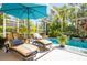 Relaxing screened pool area with lounge chairs and lush landscaping, perfect for enjoying the outdoors in comfort at 4740 Carrington Cir, Sarasota, FL 34243