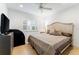 Bright bedroom features wood-look floors, a ceiling fan, and window with white shutters at 4852 Peregrine Point N Cir, Sarasota, FL 34231
