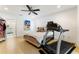 Inviting bedroom featuring a comfortable bed, a ceiling fan, and exercise equipment with a peek into the bathroom at 4852 Peregrine Point N Cir, Sarasota, FL 34231