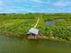 Aerial view of covered boat dock on the water surrounded by lush mangroves at 4852 Peregrine Point N Cir, Sarasota, FL 34231