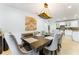 Bright dining room with a dark wood table, upholstered chairs, and an open concept view of the kitchen at 4852 Peregrine Point N Cir, Sarasota, FL 34231