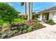 Home exterior with flowering bushes, lush shrubs, and stone pavers at 4852 Peregrine Point N Cir, Sarasota, FL 34231