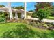 Home exterior with pavers, lawn, shrubs, and flowering bushes at 4852 Peregrine Point N Cir, Sarasota, FL 34231