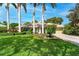 Beautiful home featuring a well-manicured lawn, mature trees, and colorful landscaping at 4852 Peregrine Point N Cir, Sarasota, FL 34231