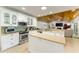 Bright kitchen with white cabinetry, stainless steel appliances, and view to the living room at 4852 Peregrine Point N Cir, Sarasota, FL 34231