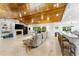 Large living room with tile floors, wood-paneled vaulted ceiling, bar seating, and fireplace at 4852 Peregrine Point N Cir, Sarasota, FL 34231