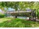 View of the screened-in pool from the lush lawn, perfect for relaxation and privacy at 4852 Peregrine Point N Cir, Sarasota, FL 34231