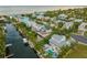 Stunning aerial view of a waterfront property with a private dock, pool, and lush tropical landscaping on a sunny day at 516 Kumquat Dr, Anna Maria, FL 34216