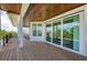 Balcony with wood-like flooring showing sliding glass doors and views of lush landscaping at 516 Kumquat Dr, Anna Maria, FL 34216