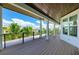 Balcony with wood-like flooring showing views of lush landscaping and blue skies at 516 Kumquat Dr, Anna Maria, FL 34216