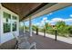 Balcony with wood-like flooring with views of lush landscaping under a blue sky at 516 Kumquat Dr, Anna Maria, FL 34216