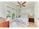 Light-filled bedroom with ceiling fan, wood floors, and access to a private balcony at 516 Kumquat Dr, Anna Maria, FL 34216