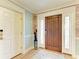 Inviting foyer with a hardwood floor, wood door with sidelights, and decorative wallpaper at 516 Kumquat Dr, Anna Maria, FL 34216