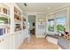 Hallway with window seat, view to the living room, and built-in bookshelf at 516 Kumquat Dr, Anna Maria, FL 34216