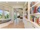 Hallway with beautiful built-in bookshelves and a view into a bedroom with exposed ceiling beams at 516 Kumquat Dr, Anna Maria, FL 34216