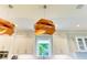 Gourmet kitchen with custom wood light fixtures and bright white cabinets at 516 Kumquat Dr, Anna Maria, FL 34216