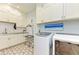 Well-organized laundry room featuring ample storage, modern appliances, and stylish tile flooring at 516 Kumquat Dr, Anna Maria, FL 34216