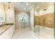 Elegant bathroom featuring decorative wallpaper, marble floors, a glass shower, and granite countertops at 516 Kumquat Dr, Anna Maria, FL 34216
