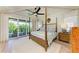 Bright main bedroom with a ceiling fan and sliding glass door to balcony with beautiful views at 516 Kumquat Dr, Anna Maria, FL 34216