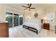 Bright main bedroom with access to a private balcony, hardwood floors, and tasteful decor at 516 Kumquat Dr, Anna Maria, FL 34216