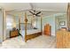 Bright main bedroom features a ceiling fan, wood floors, and large windows for ample natural light at 516 Kumquat Dr, Anna Maria, FL 34216