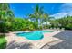 Beautiful backyard pool and jacuzzi surrounded by lush landscaping and brick pavers at 516 Kumquat Dr, Anna Maria, FL 34216