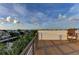 Roof deck with a chair and wood-like flooring shows lovely waterfront views at 516 Kumquat Dr, Anna Maria, FL 34216
