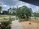Charming landscaped front yard with lush plants, a stone pathway and verdant green lawn at 5180 Guava Ter, Port Charlotte, FL 33981