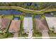 Aerial view of a beautiful home with a pool and well-manicured landscaping, adjacent to a serene pond at 5557 Long Shore Loop, Sarasota, FL 34238
