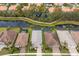 Aerial view showcasing a row of houses with screened-in pools backing onto a picturesque waterway surrounded by lush greenery at 5557 Long Shore Loop, Sarasota, FL 34238