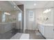 Luxurious bathroom showcasing a glass shower, tile flooring, and a double sink vanity at 5557 Long Shore Loop, Sarasota, FL 34238