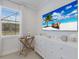 Bright bedroom featuring a dresser with a large TV and a window with blinds at 5557 Long Shore Loop, Sarasota, FL 34238