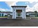 Welcoming entrance to the Mattamy Homes at Tradition community center featuring grand columns and beautiful landscaping at 5557 Long Shore Loop, Sarasota, FL 34238