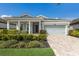 Charming home with manicured landscaping, a covered porch, and a two-car garage at 5557 Long Shore Loop, Sarasota, FL 34238