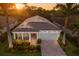 Aerial view of a landscaped single-story home with a large roof, and brick driveway at 5557 Long Shore Loop, Sarasota, FL 34238