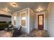 Inviting covered front porch features stylish chairs, a small table, and a brick-paved floor at 5557 Long Shore Loop, Sarasota, FL 34238