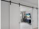 Inviting home office with sliding barn doors, a TV, and a stylish chandelier for a productive workspace at 5557 Long Shore Loop, Sarasota, FL 34238